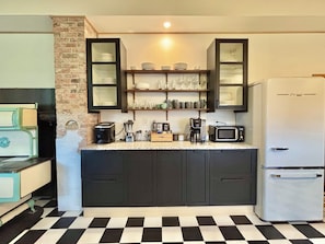 A kitchen with dark cabinets, a white refrigerator, a microwave, and a coffee maker.
