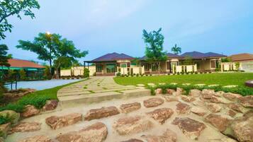 A hotel with multiple buildings, a stone pathway, and a well-maintained lawn.