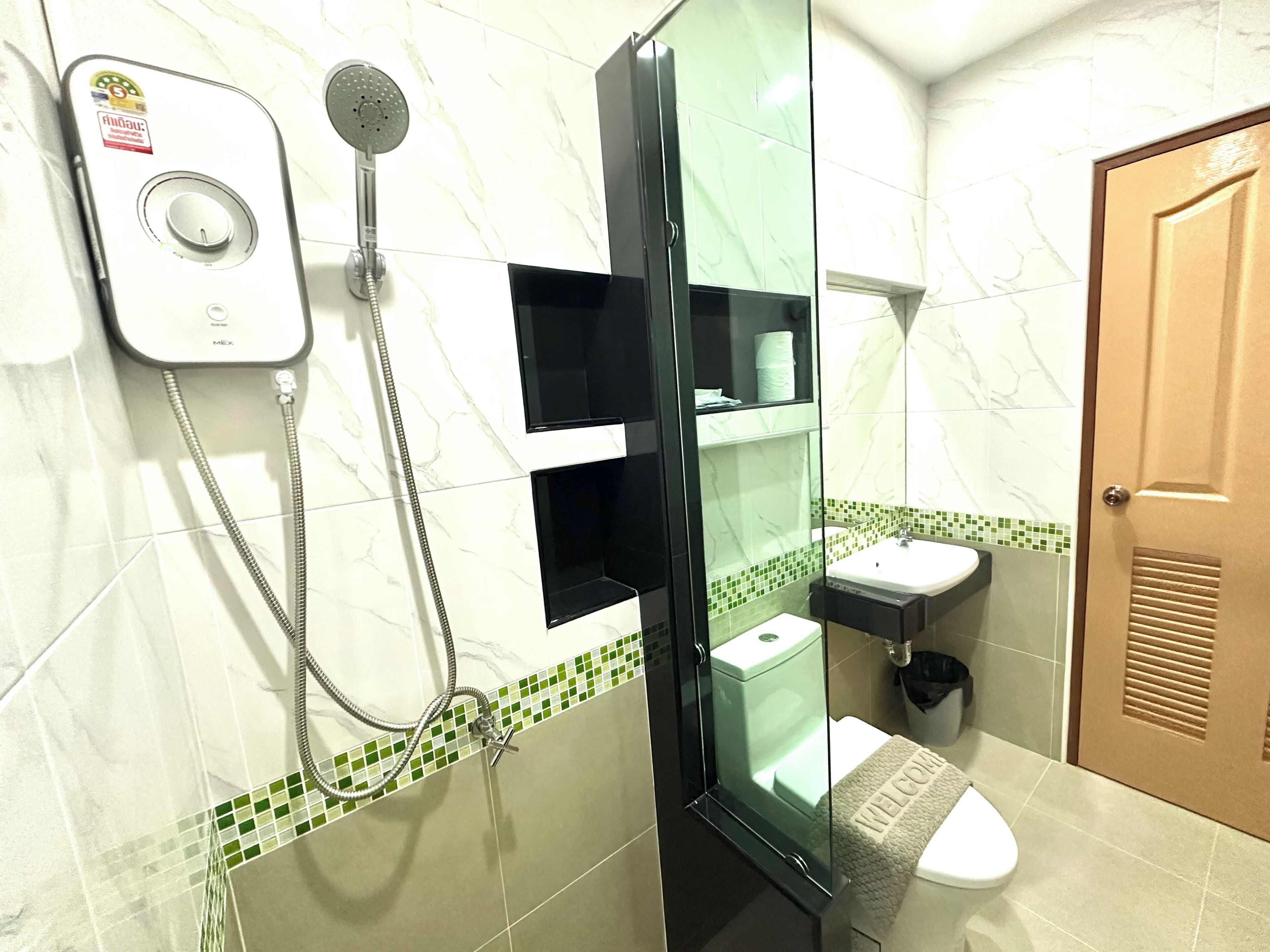A bathroom with a glass-enclosed shower, a white sink, and a toilet.