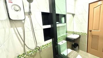 A bathroom with a glass-enclosed shower, a white sink, and a toilet.