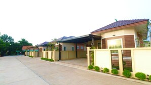 Área residencial com casas, entrada por um caminho de paralelepípedos e portão.