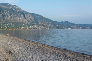 A pebbled beach with a mountain in the background. - Traditional sea front villa, close to reasturants & cafes
With garden & sea view (Kalamata)