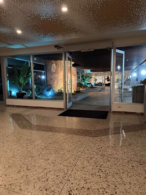 A lobby with a glass entrance, a tiled floor, and a decorative ceiling. - My Paradise: Tropical, 3-star, beach, sand—everything at your fingertips (Carolina Puerto Rico)