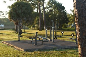 Ein Park mit Trainingsgeräten, Bäumen und blauem Himmel.