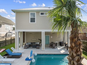 A two-story house with a covered patio area, a swimming pool, and outdoor furniture. - Bayou Breeze  - Pool + Waterfront Views + 8 Minutes to Downtown Pensacola (Pensacola)