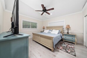 A bedroom with a bed, bedside tables, a ceiling fan, a desk, and a window with blinds. - Bright and Peaceful Modern Home - Sleeps 5 (Sanford)