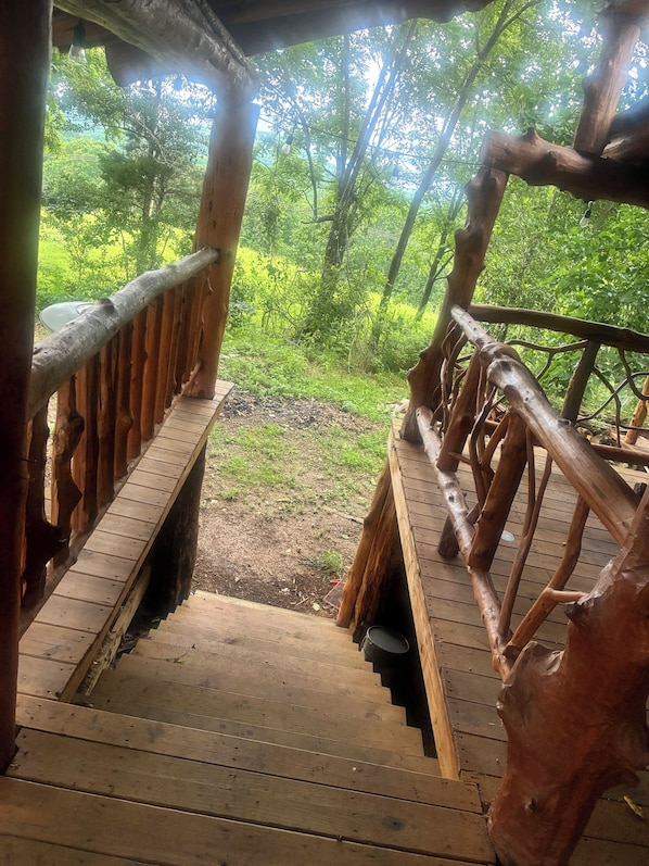 Una escalera de madera que conduce a un espacio exterior con vistas a un bosque.