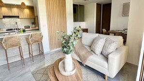 Un salon moderne avec un canapé, une table basse et des fauteuils.