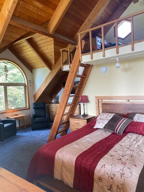 A bedroom with a loft bed, a wooden ladder, a desk, a chair, and a large window. - Beautiful 2-bedroom Home: Private and Family Friendly (Homer)