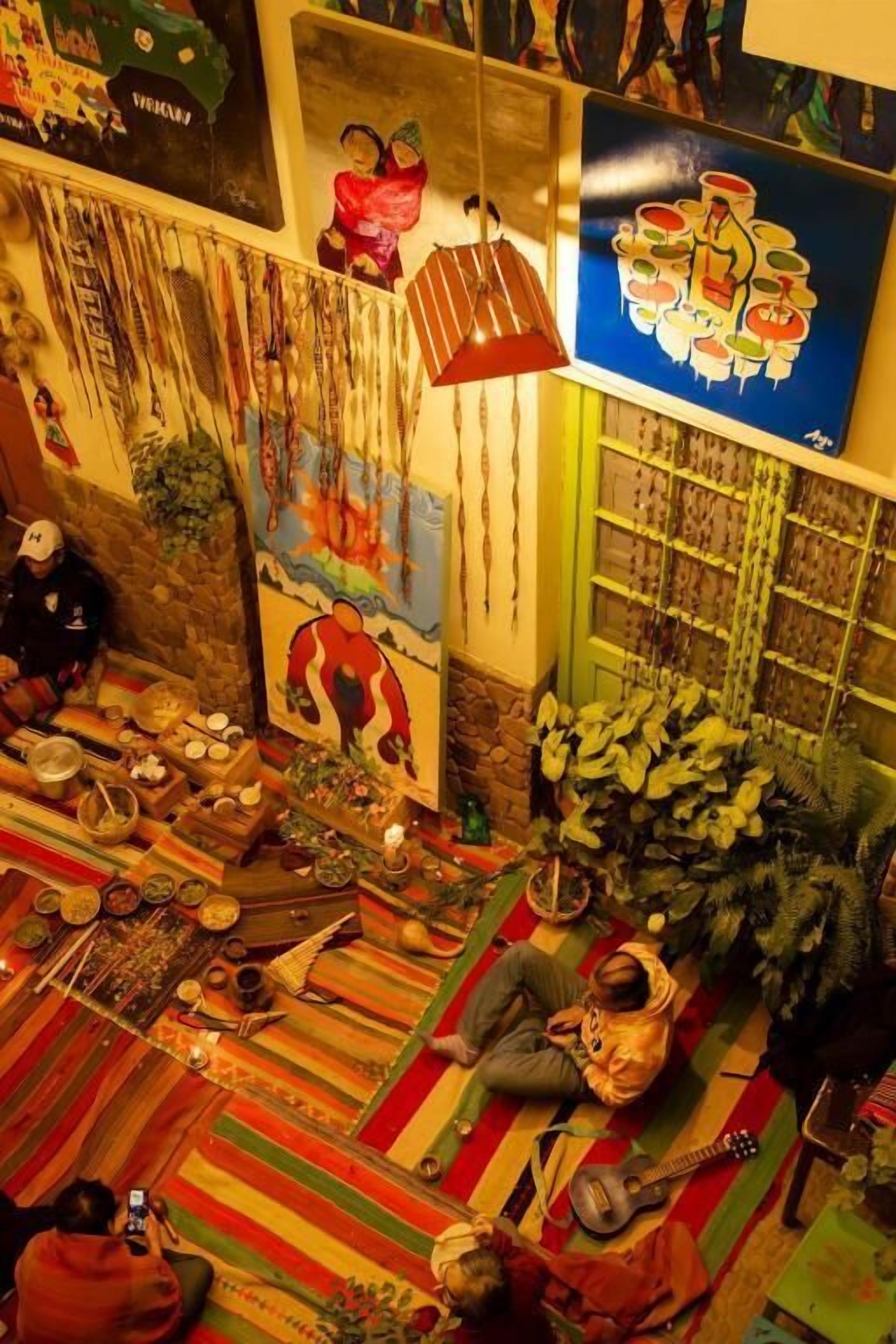 A room with a colorful carpet, a large painting, and various decorative items on the walls.
