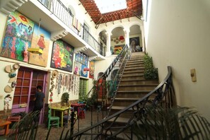A narrow staircase with a metal railing, leading to a second-floor balcony with a tiled roof. - Hostel Cultural Pata y Perro (Tarija)