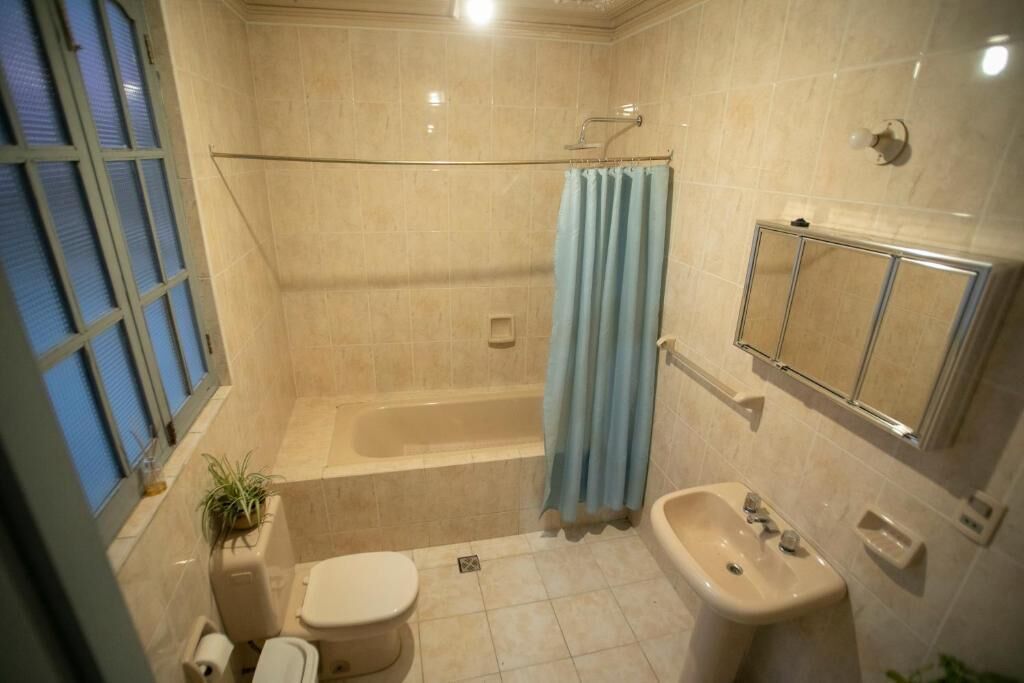 Baño con bañera, inodoro, lavabo y cortina de ducha.