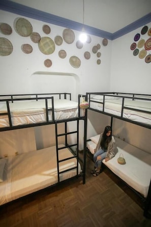 A room with bunk beds, a ladder, and a wall decorated with circular woven items. - Hostel Cultural Pata y Perro (Tarija)