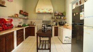 Una cocina con armarios de madera, una isla central, una estufa y un refrigerador.