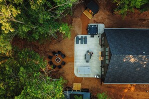 An aerial view of a property with a patio area, outdoor seating, and a building with a sloped roof. - Cozy Lakefront Retreat | Sauna, Hot Tub & Ski (Wild Rose)
