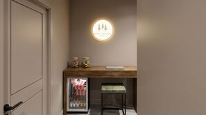 A kitchenette with a wooden countertop, two jars of candy, a laptop, a refrigerator stocked with beverages, and a bench. - Cozy Lakefront Retreat | Sauna, Hot Tub & Ski (Wild Rose)