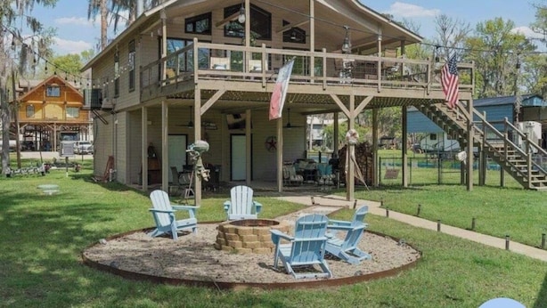 A two-story wooden building with a balcony, outdoor seating, and a flag.