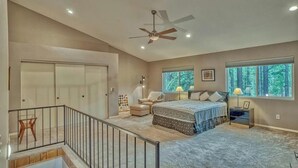 A bedroom with a bed, a chair, a nightstand, a window, and a ceiling fan. - Pinetop Sinatra Getaway (Pinetop Country Club)