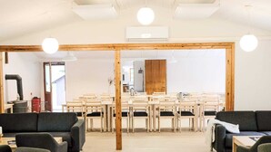 A modern interior with a central dining area, wooden beams, and a large mirror. - 4 Star Holiday Home in Aakirkeby (Akirkeby)
