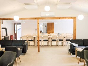 Ein modernes Interieur mit einer zentralen Essecke, Holzbalken und einem großen Spiegel.