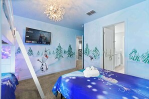 Ein Schlafzimmer mit einem Bett, einem an der Wand montierten Fernseher und einem Wandgemälde zum Winterschlussverkauf.