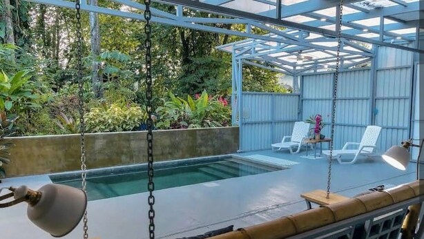 A covered outdoor area with a pool, lounge chairs, and a swing. - Beautiful 1-bedroom with Private Pool in Playa Negra Puerto Viejo (Playa Negra, Puerto Viejo de Talamanca)