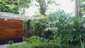 A modern building with a wooden facade, surrounded by lush tropical vegetation. - Beautiful 1-bedroom with Private Pool in Playa Negra Puerto Viejo (Playa Negra, Puerto Viejo de Talamanca)