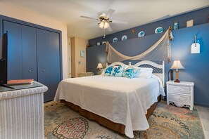 A bedroom with a bed, a ceiling fan, a nightstand, and a wall with decorative plates. - Charming 4-bedroom house in Fruit and Wine country  Palisade! Retired BnB (Palisade)