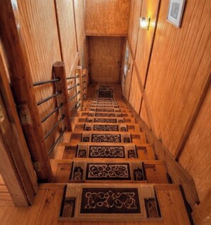 A wooden staircase with intricate carvings, leading to a higher floor.