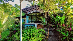 A modern structure with a glass enclosure, surrounded by lush tropical vegetation. - Pond House l Waterfront Jungle Retreat w/Private Pool, Fire Pits, Hammocks & AC (Provincia de Puntarenas)