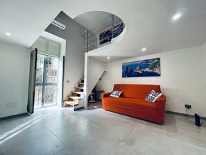 Een modern interieur met een trap, een bank en een schilderij.
