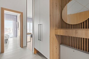 Ein modernes Hotelzimmer mit einem großen Spiegel, Holzvertäfelung und Blick auf die Stadt.