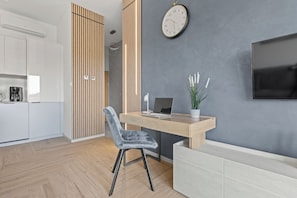 A modern kitchen with white cabinets, a coffee maker, and a wooden divider. - OHANA 5 Mrzeżyno - Beachfront Apartment (Mrzeżyno)