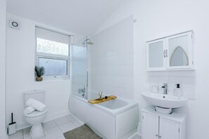 A modern bathroom with a glass-enclosed shower, a white toilet, a bathtub, and a sink with a mirror cabinet. - 3 BR House | Sleeps 7 | Free Parking | Fast Wi-Fi (Salford)