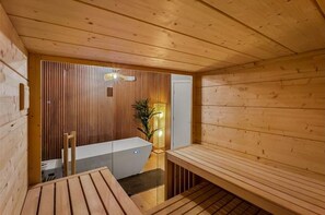 Uma sala de sauna com paredes de madeira e um banco.