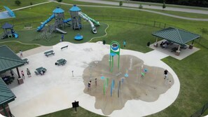 Un'area giochi con scivoli, strutture per arrampicata e una zona relax riparata.