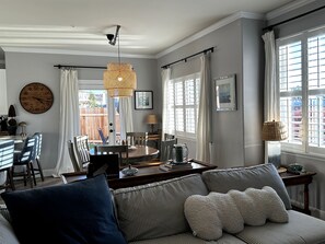 A dining area with a round table, chairs, and a hanging light fixture. - 3-bedroom pet-friendly house in Grover Beach - 2 miles from the Beach (Grover Beach)