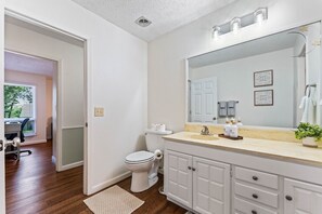 Ein Badezimmer mit Toilette, Waschbecken, Waschtisch und einem großen Spiegel.
