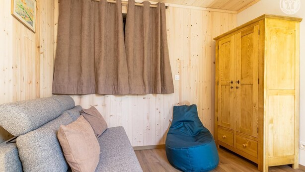 A wooden interior with a sofa, a bean bag, and a wardrobe. - La Correrie des Chartreux (AILLON LE JEUNE)