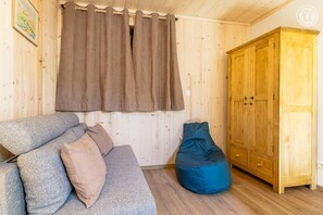 A wooden interior with a sofa, a bean bag, and a wardrobe. - La Correrie des Chartreux (AILLON LE JEUNE)