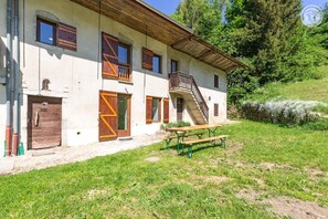 Ein rustikales Gebäude mit einer Holztreppe, einer Haustür und einem Picknicktisch.