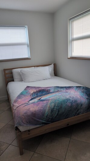 A bed with a colorful blanket, a wooden headboard, and two windows with blinds. - Waterfront~Boat Deck, Pool home near Hard Rock~FLL Airport & FIFA World Cup (Fort Lauderdale)