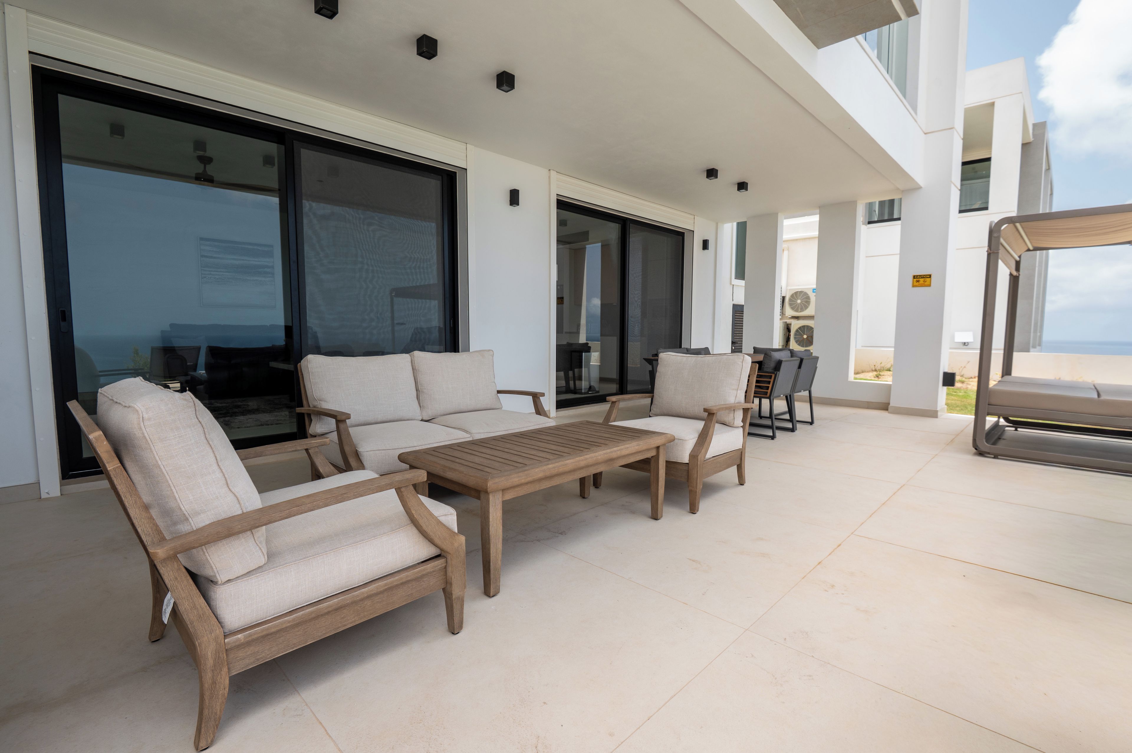 A modern outdoor seating area with a sofa, chairs, and a table.