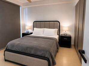 Ein modernes Schlafzimmer mit einem Bett, zwei Nachttischen mit Lampen, einem großen Fenster und einer Tür.