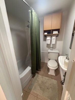 Ein Badezimmer mit Badewanne, Toilette, Waschbecken und Handtuchhalter.