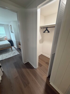 Ein Schlafzimmer mit einem Bett, einem Nachttisch und einem Fenster mit Jalousien.