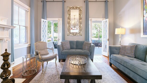 A living room with a sofa, armchair, coffee table, and a decorative mirror. - Spacious Historic 2BR w/ Courtyard, Parking, Walk to Forsyth Park (Savannah)