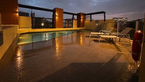 A rooftop pool area with a clear view of the city skyline at dusk. - Queen Street CBD Stay with Balcony and Amenities (Brisbane City)