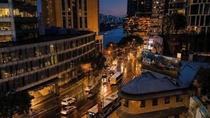 A cityscape at dusk with buildings, a river, and a busy street. - Queen Street CBD Stay with Balcony and Amenities (Brisbane City)