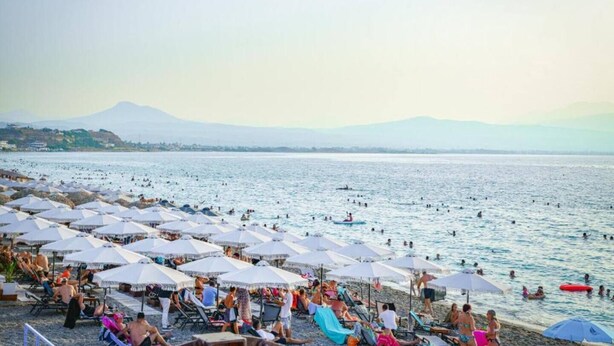 A beach with umbrellas and people swimming. - Beach Blue Villa , Luxury 3-Bedroom Villa with Sea View (Korinthos)